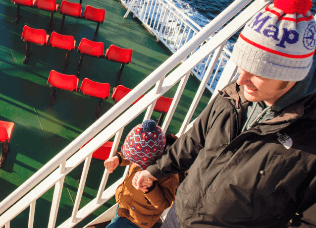 A man and his child holding hands on a Calmac ferry